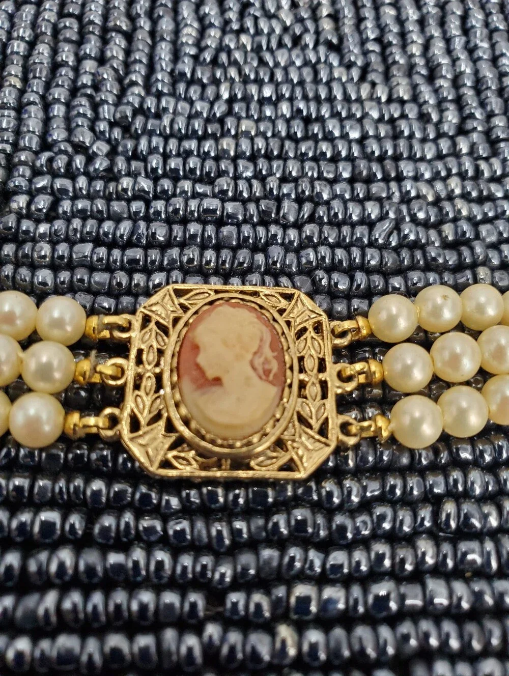 Vintage-style 3-strand pearl choker necklace with a prominent cameo centerpiece